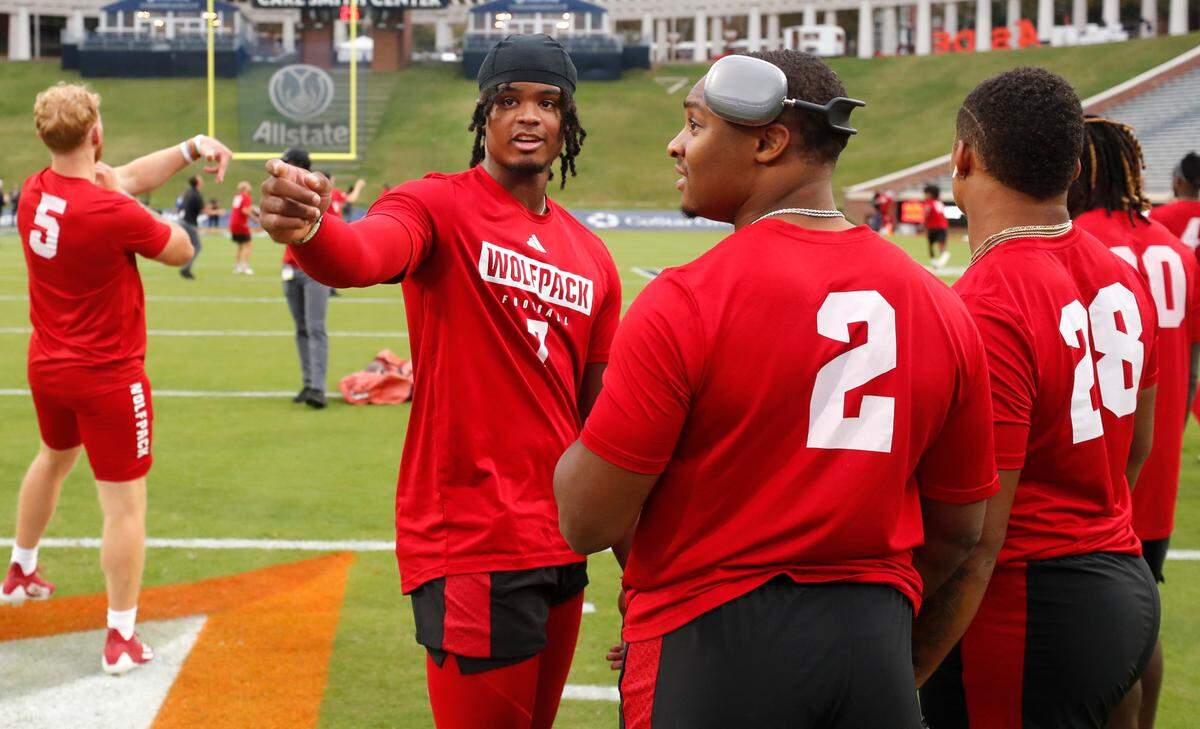 N.C. State quarterback MJ Morris (7) talks with running back Michael Allen (2) during warmups before N.C. State’s game against Virginia at Scott Stadium in Charlottesville, Va., Friday, Sept. 22, 2023.