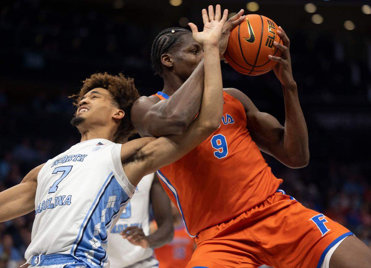 Florida’s Reuben Chinyelu (9) secures an offensive rebound from North Carolina’s guard Seth Trimble (7) in the first half during the Jumpman Invitational on Tuesday, December 17, 2024 at the Spectrum Center in Charlotte, N.C.