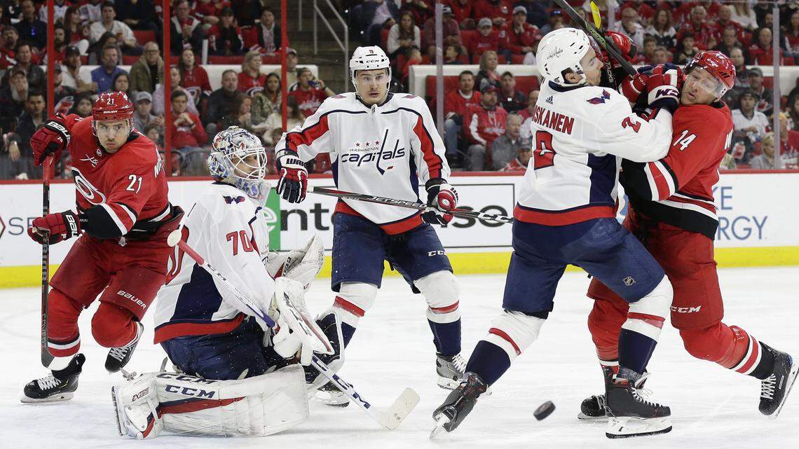 Carolina Hurricanes’ Justin Williams (14) and Washington Capitals’ Matt Niskanen (2) struggle in front of Capitals’ Dmitry Orlov (9), of Russia, and goalie Braden Holtby (70) while Hurricanes’ Nino Niederreiter (21), of the Czech Republic, skates during the third period of an NHL hockey game in Raleigh, N.C., Thursday, March 28, 2019. Washington won 3-2.