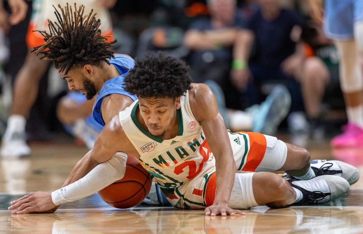 North Carolina’s R.J. Davis (4) battles for a loose ball with Miami’s Nijel Pack (24) in the first half on Saturday, February 10, 2024 at the Watsco Center in Coral Gables, Florida.