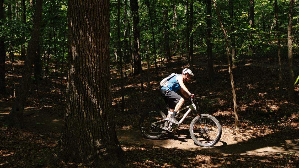 A person rides a bike on a trail at Lake Crabtree County Park on May 1, 2025. The park’s multiuse trails permanently closed on Sunday, June 1. 