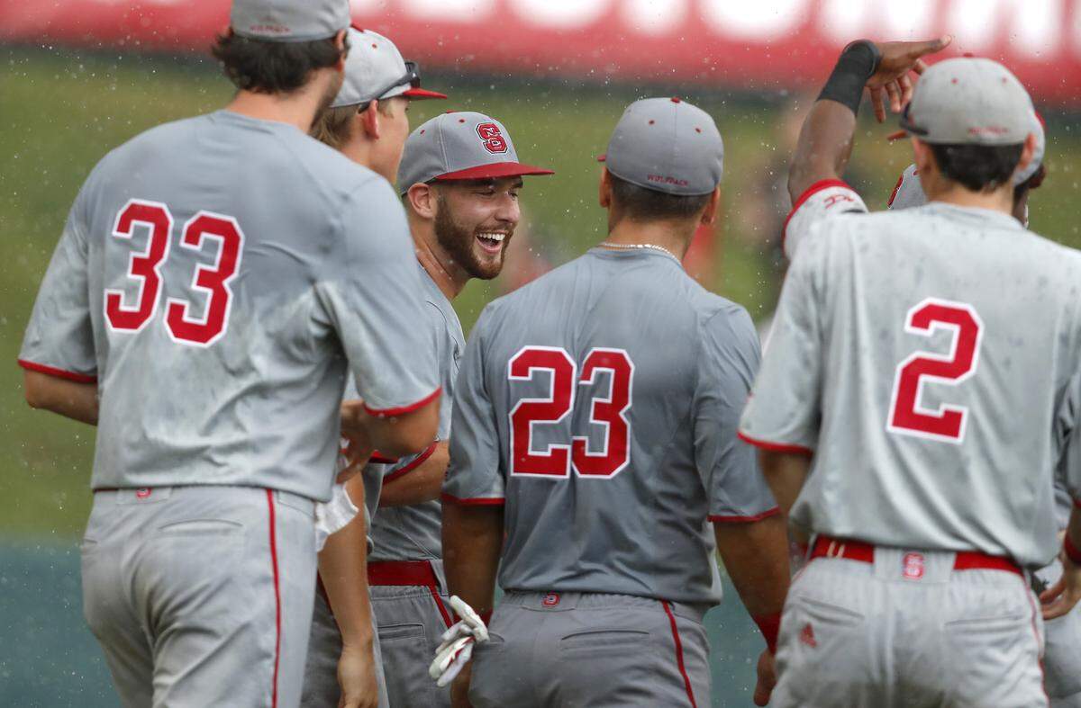N.C. State pitcher Brian Brown, center left, celebrates with teammates after the Wolfpack's 9-3 victory over Northeastern in the Raleigh Regional Saturday, June 2, 2018.
