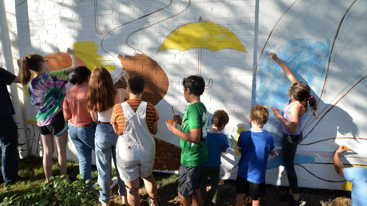 A few dozen residents and neighbors of Durham’s Lakewood neighborhood updated and redesigned a 1998 mural Saturday, Oct. 12, 2019. The mural will be displayed on the outside wall of El Futuro, a mental health clinic serving Latino residents.