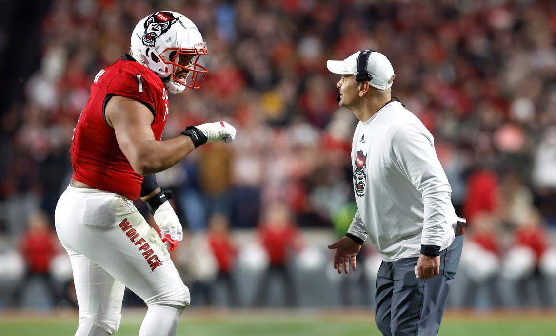 N.C. State defensive tackle Davin Vann (1) celebrates with defensive coordinator Tony Gibson during the first half of N.C. State’s game against UNC at Carter-Finley Stadium in Raleigh, N.C., Saturday, Nov. 25, 2023.