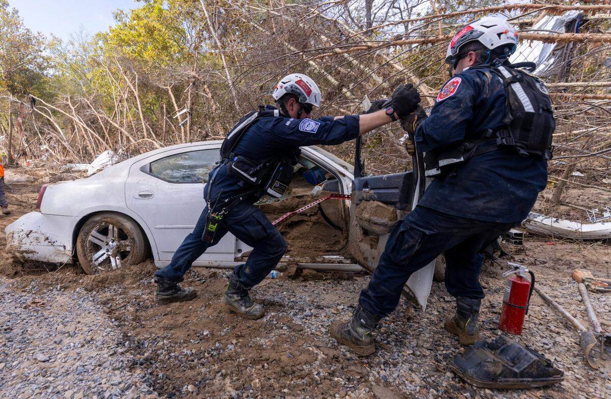 A FEMA search and rescue team from Maryland search for human remains in car in Swannanoa on Sunday, Oct. 6, 2024 after Tropical Storm Helene flooded the Swannanoa River. North Carolina officials have confirmed 76 deaths from Tropical Storm Helene.