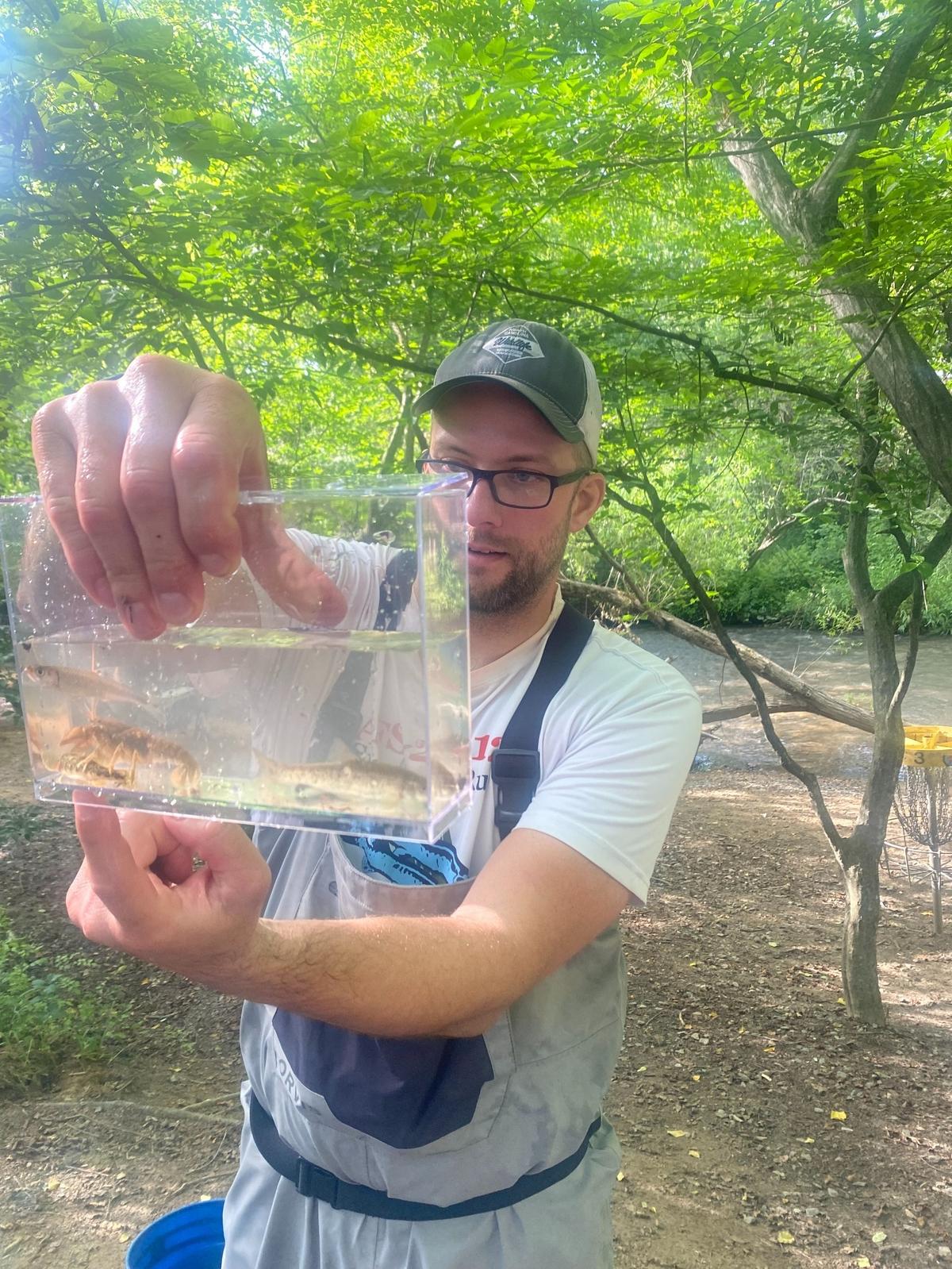 Luke Etchison of the NC Wildlife Resources Commission shows off the aquatic wildlife collected just before the inaugural snorkel in the Swannanoa River, including a yet unidentified crayfish.