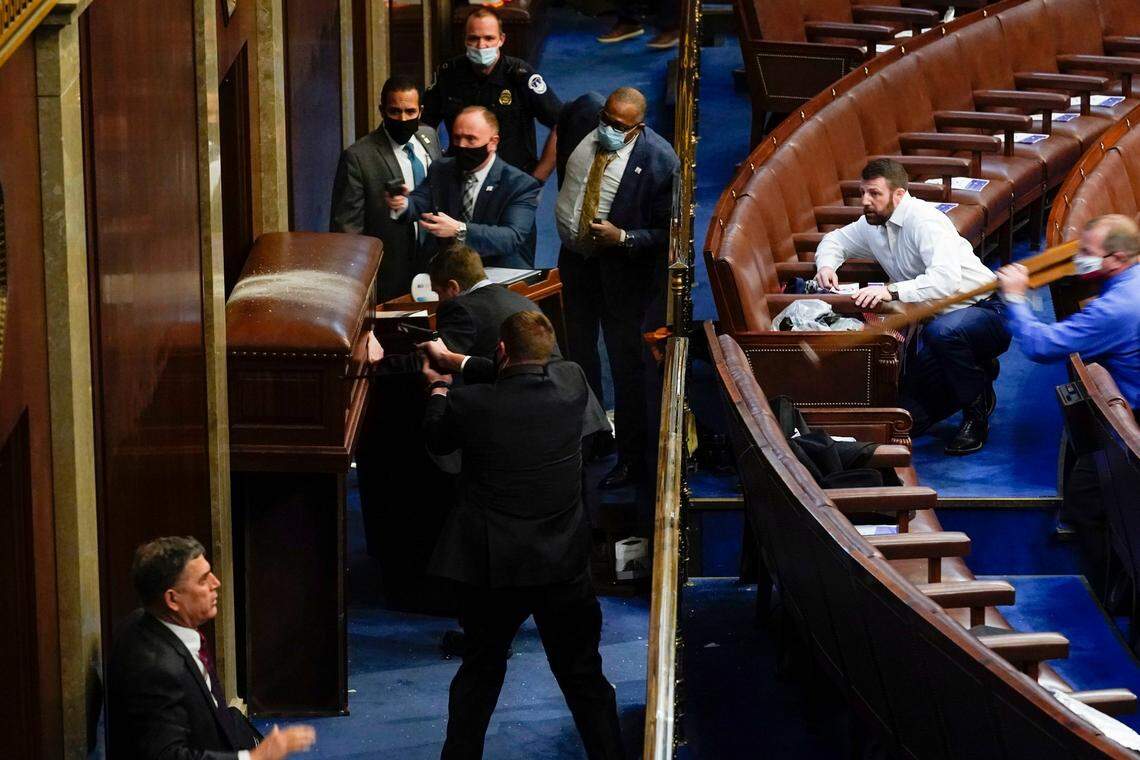 U.S. Capitol Police with guns drawn stand near a barricaded door as protesters try to break into the House Chamber at the U.S. Capitol on Wednesday, Jan. 6, 2021, in Washington. (AP Photo/Andrew Harnik)