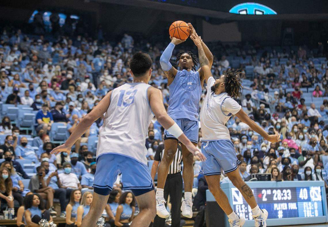 North Carolina’s Caleb Love (2) shoots over R.J. Davis (4) and Dawson Garcia (13) during a scrimmage at Late Night on Friday, October 15, 2021 at the Smith Center in Chapel Hill, N.C.
