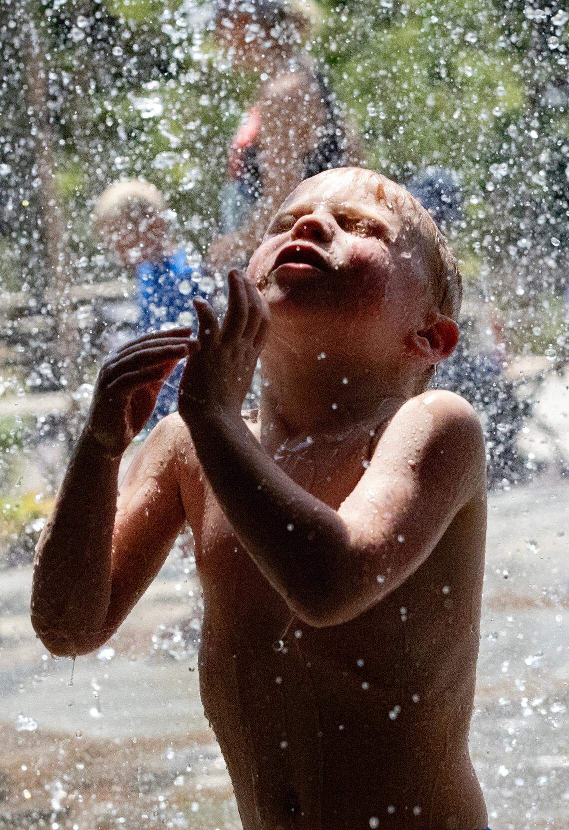 Allen Rammer plays under the waterfall at Gipson Play Plaza in Raleigh, N.C. on Thursday, July 3, 2025. It was the hottest July on record in Raleigh, with an average temperature of 84 degrees and an average daily high of 93.5 degrees, the National Weather Service said.