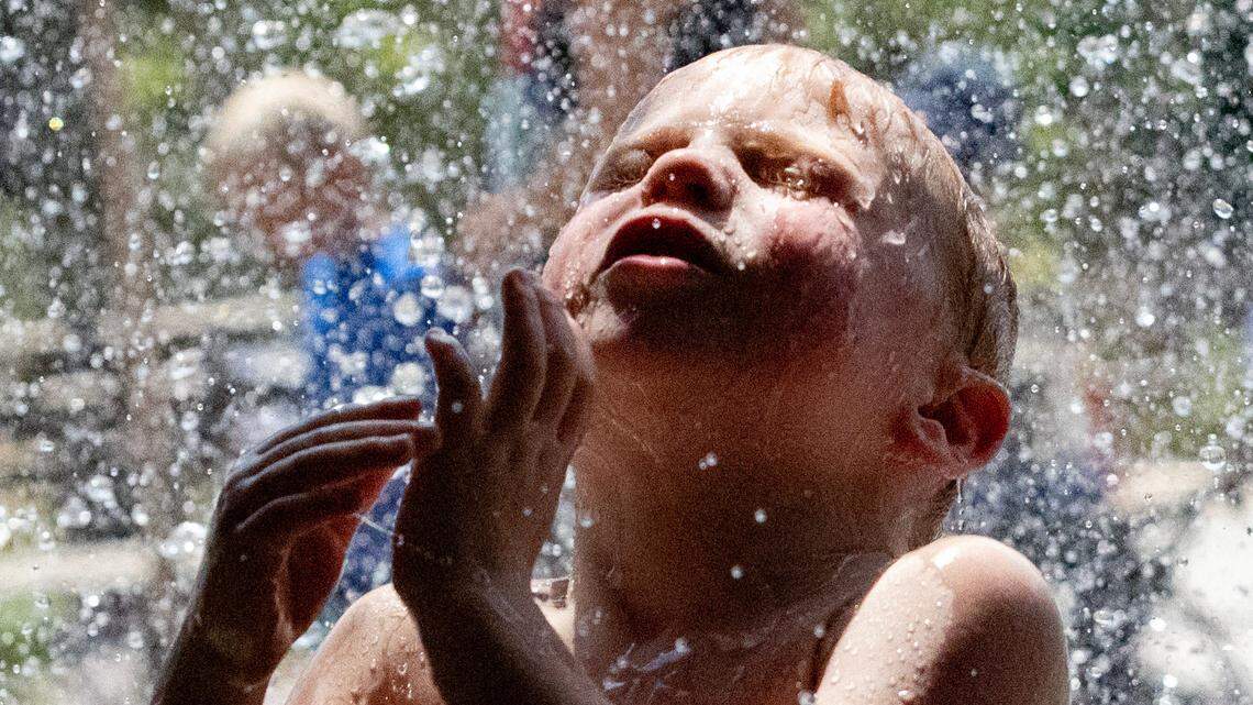 Allen Rammer plays under the waterfall at Gipson Play Plaza in Raleigh, N.C. on Thursday, July 3, 2025. It was the hottest July on record in Raleigh, with an average temperature of 84 degrees and an average daily high of 93.5 degrees, the National Weather Service said.