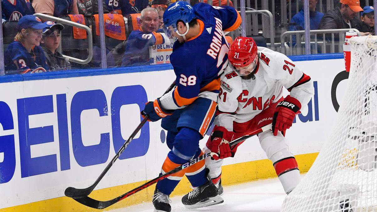 New York Islanders defenseman Alexander Romanov (28) battles for the puck with Carolina Hurricanes center Derek Stepan (21) behind the net during the first period in game three of the first round of the 2023 Stanley Cup Playoffs at UBS Arena.
