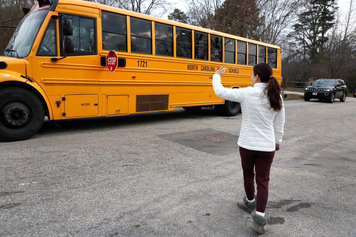 Ilsy Chappell waves goodbye after her daughter Sienna, a third-grader at Hunter Elementary School, boarded the school bus in Raleigh, N.C., Tuesday, Jan. 17, 2023.