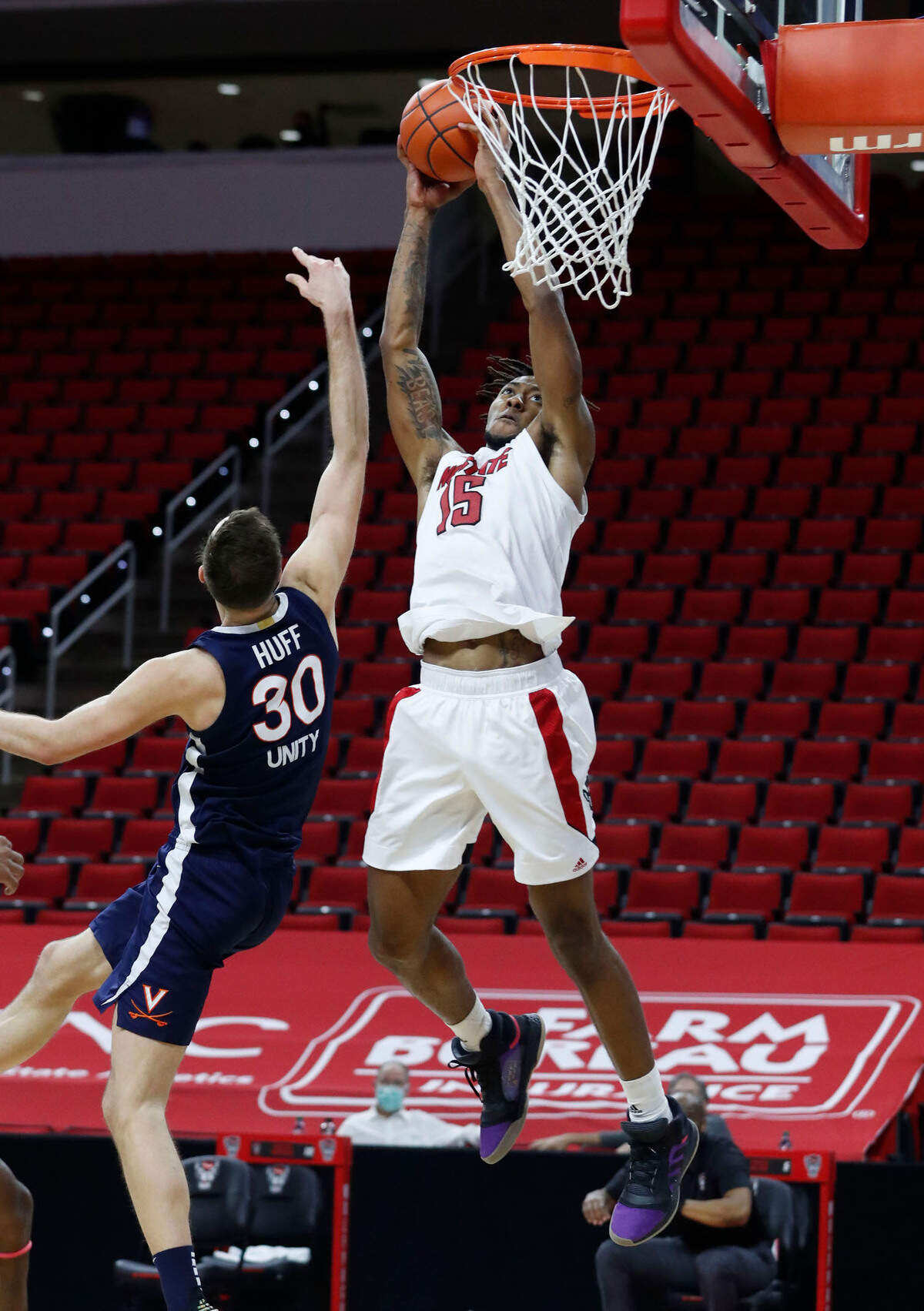 N.C. State’s Manny Bates (15) heads to slam in two as Virginia’s Jay Huff (30) defends during the second half of Virginia’s 64-57 victory over N.C. State at PNC Arena in Raleigh, N.C., Wednesday, February 3, 2021.