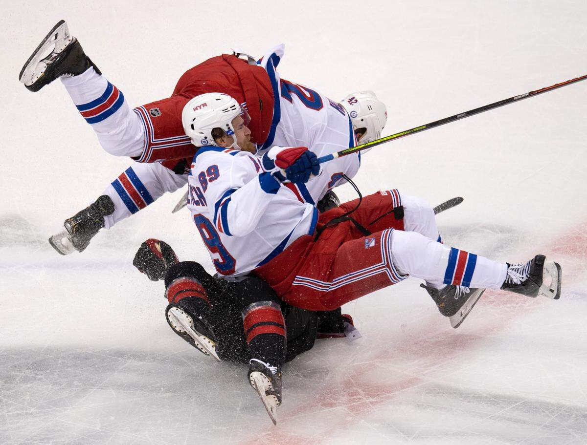 New York Rangers right wing Pavel Buchnevich (89) and defenseman Brendan Smith (42) knock Carolina Hurricanes center Martin Necas (88) to the ice during the first period in the NHL hockey Stanley Cup playoffs in Toronto, Saturday, Aug. 1, 2020. (Frank Gunn/The Canadian Press via AP)