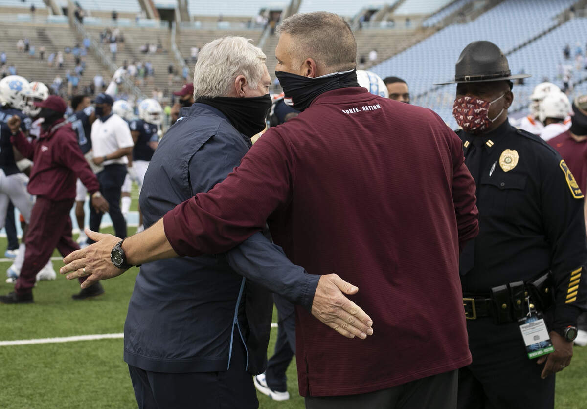 Virginia Tech head coach Justin Fuente embraces North Carolina coach Mack Brown following the Tar Heel’s 56-49 victory on Saturday, October 10, 2020 at Kenan Stadium in Chapel Hill, N.C.