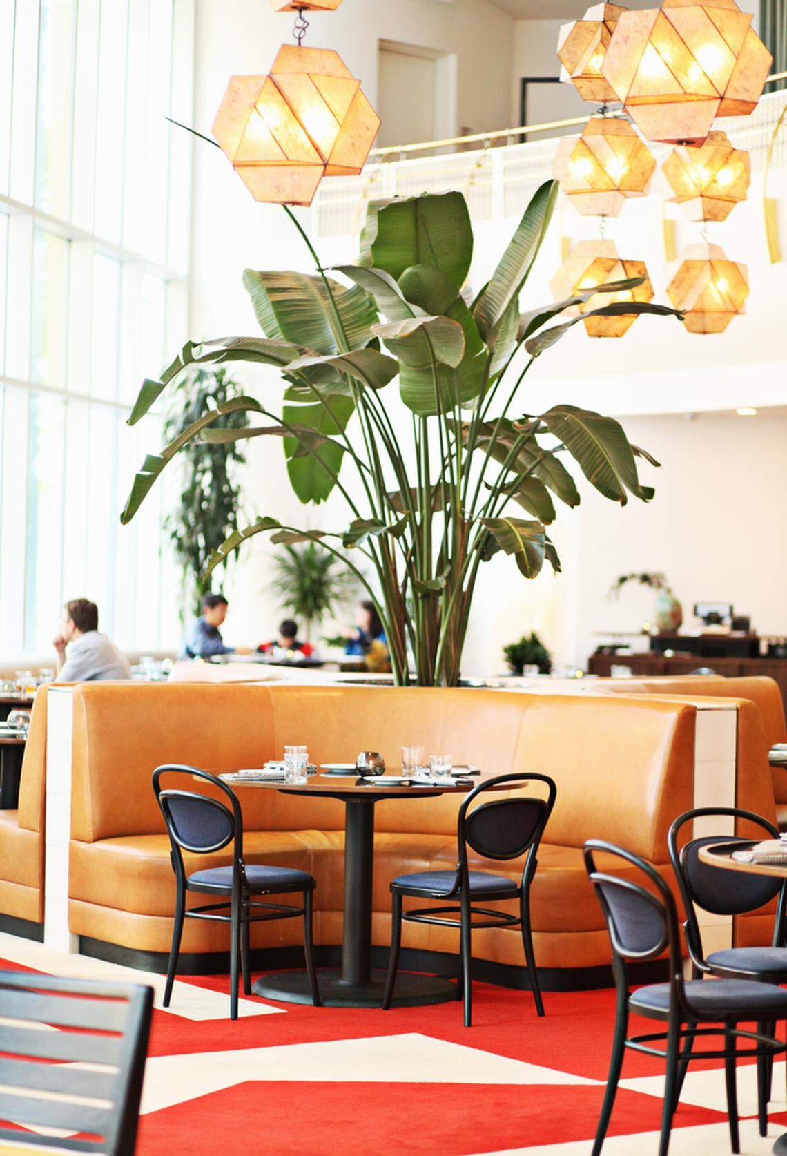 The Durham’s dining room is an airy, casually inviting space whose vibrant mid-century modern decor takes its cues from the former Home Savings Bank building, an iconic 1968 structure that has been restored.