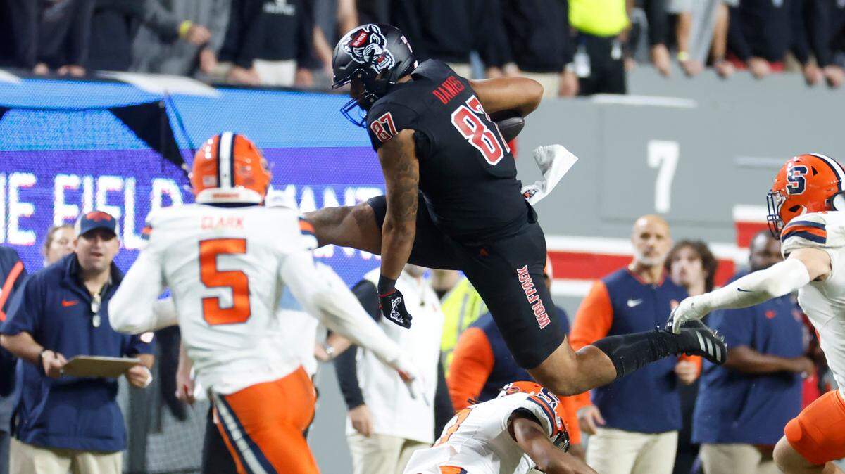 N.C. State tight end Dante Daniels (87) hurdles over Syracuse defensive back Clarence Lewis (3) during the second half of Syracuse’s 24-17 victory over N.C. State at Carter-Finley Stadium in Raleigh, N.C., Saturday, Oct. 12, 2024.