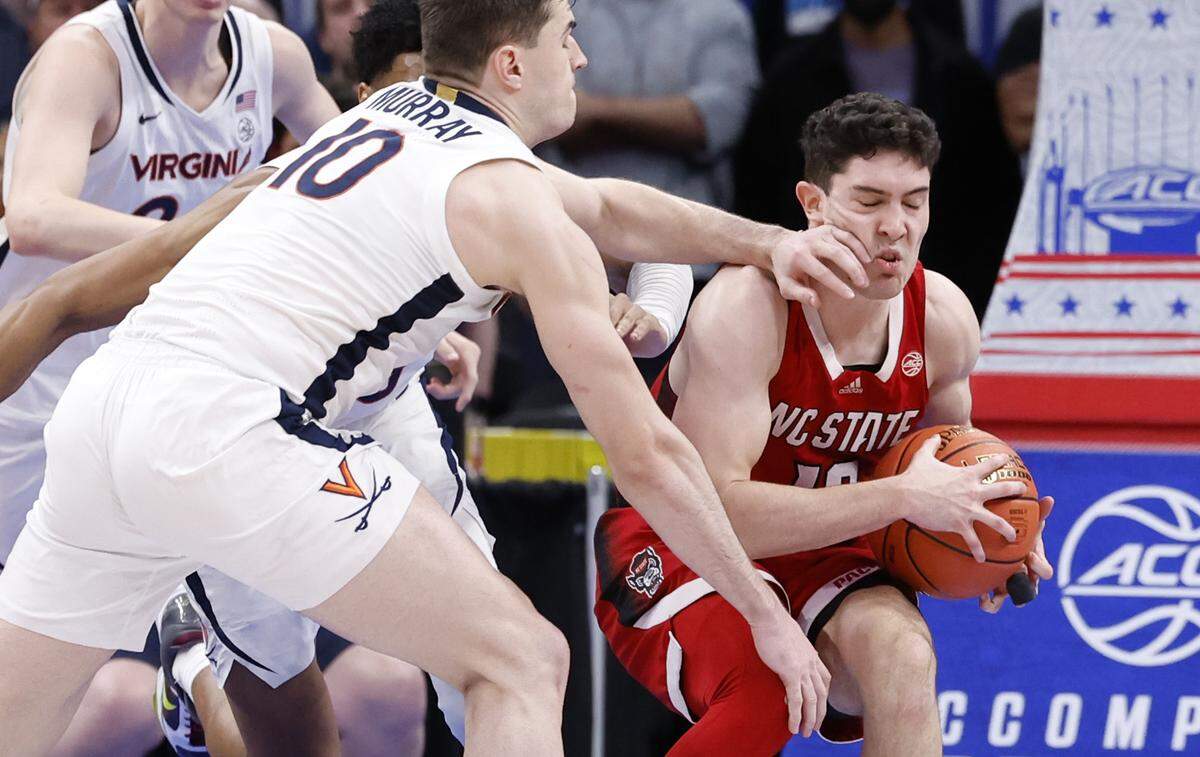 N.C. State’s Michael O’Connell (12) pulls in the rebound from Virginia’s Taine Murray (10) during N.C. State’s 72-65 overtime victory over Virginia in the semifinals of the 2024 ACC Men’s Basketball Tournament at Capital One Arena in Washington, D.C., Friday, March 15, 2024.