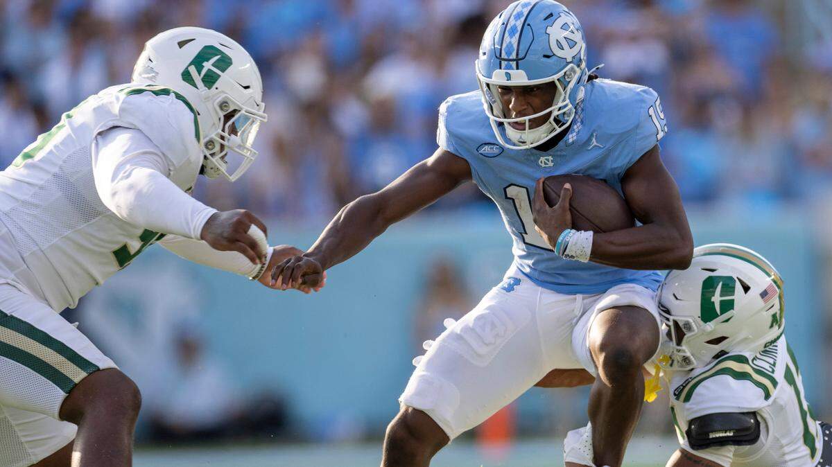 Charlotte defensive lineman Dre Martin (99) and defensive back CJ Clinkscales (12) work to slow North Carolina quarterback Conner Harrell (15) in the third quarter on Saturday, September 7, 2024 at Kenan Stadium in Chapel Hill, N.C.