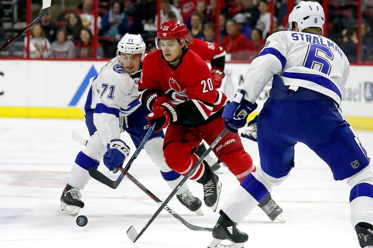 The Canes’ Sebastian Aho (20) drives between the Lightning’s Anthony Cirelli (71) and Anton Stralman (6) during the Hurricanes last game of the season against the Tampa Bay Lightning at PNC Arena in Raleigh, N.C. on April 7, 2018.
