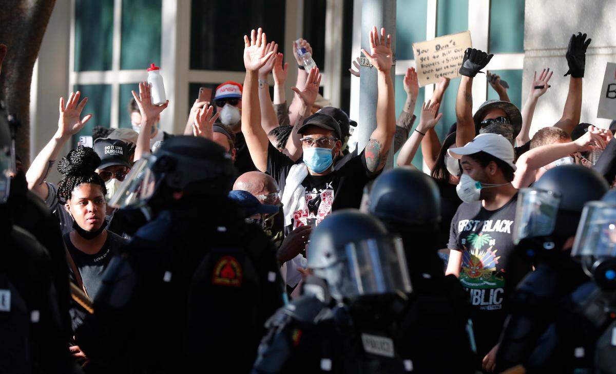 Demonstrators face off with police in riot gear during a protest in downtown Raleigh, N.C. Saturday, May 30, 2020.