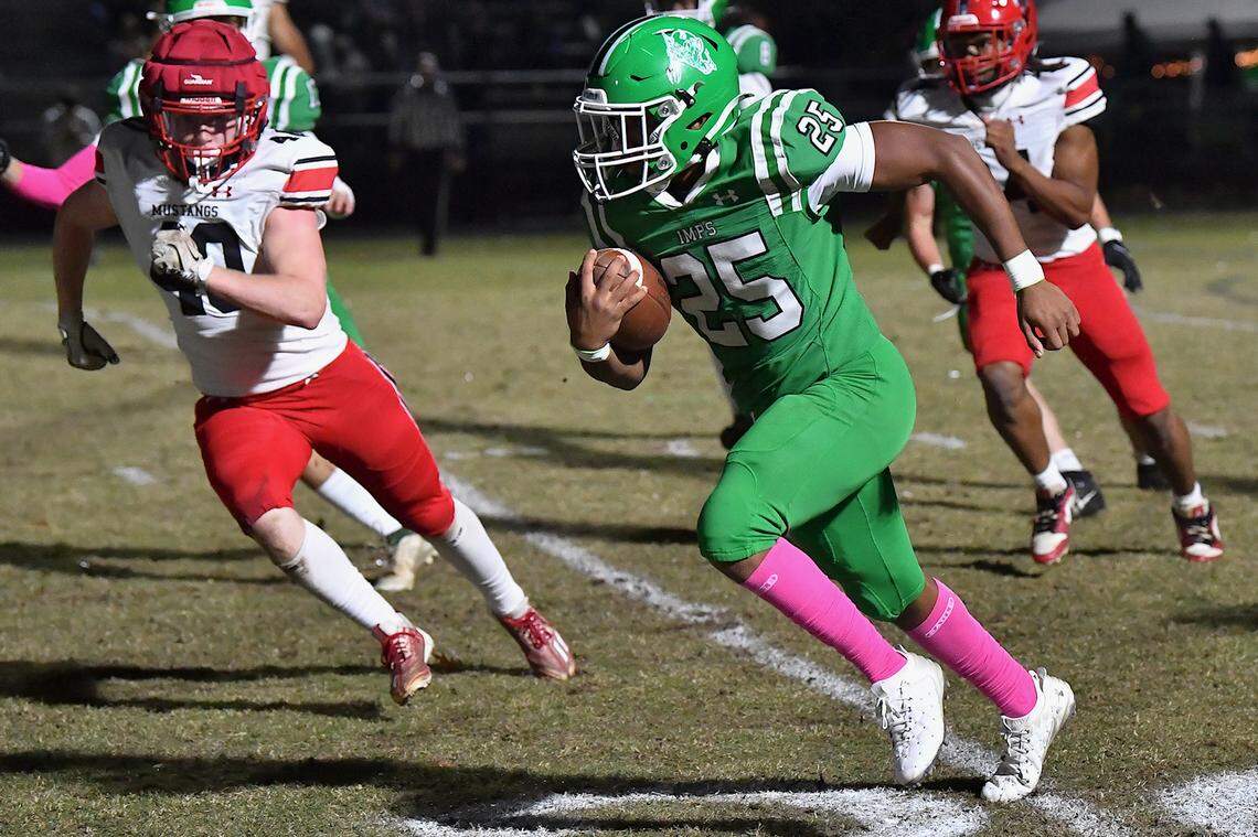 Cary's Skylan Joyner (25) rushes for yards against Middle Creek's Mark Smith (40) during the first half. The Cary Imps and the Middle Creek Mustangs met in a conference football game in Cary, N.C. on October 24, 2025