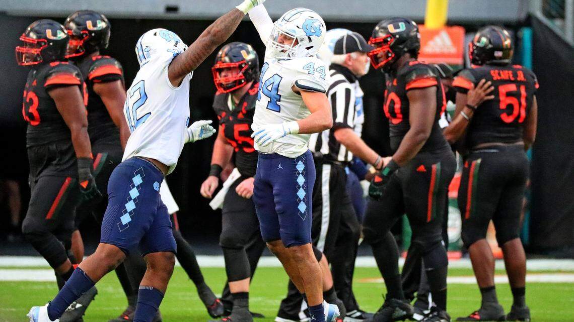 North Carolina Tar Heels linebackers Tomon Fox (12) and Jeremiah Gemmel (44) celebrate a stop in the second quarter at Hard Rock Stadium In Miami Gardens, Florida, Saturday, December 12, 2020.