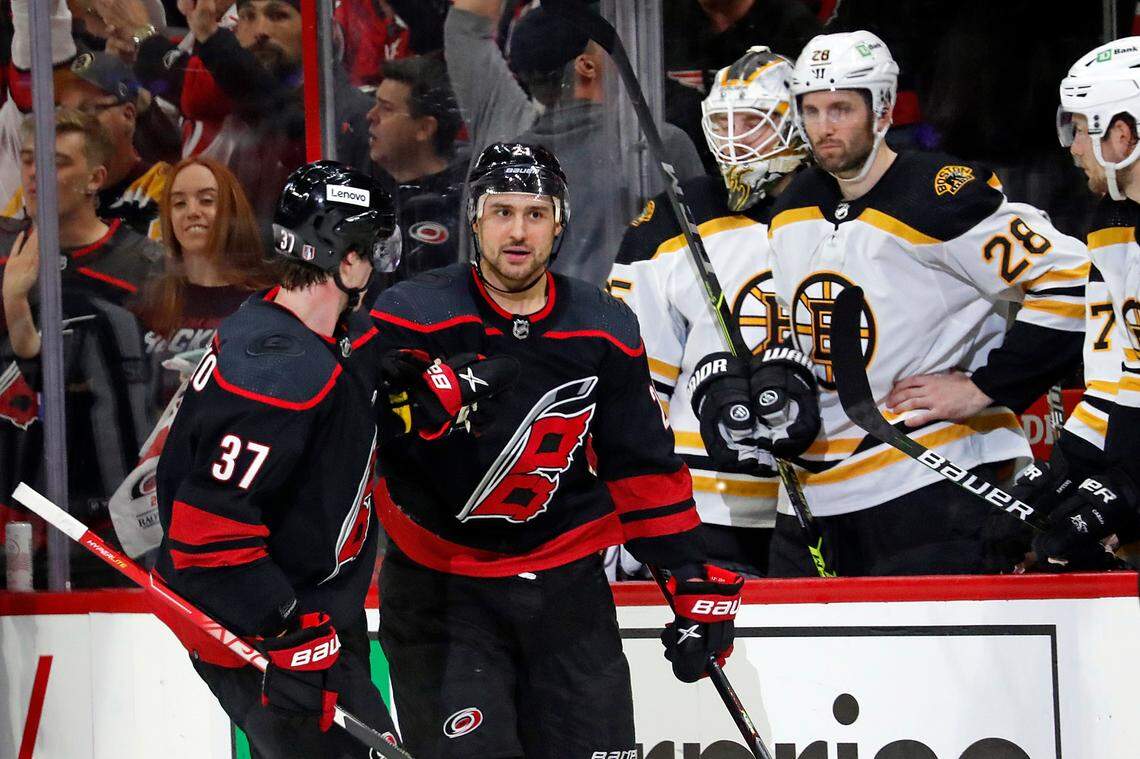 Carolina Hurricanes’ Nino Niederreiter, right front, is congratulated on his empty-net goal by Andrei Svechnikov (37) as the skate by the Boston Bruins’ bench during the third period of Game 2 of an NHL hockey Stanley Cup first-round playoff series in Raleigh, N.C., Wednesday, May 4, 2022. (AP Photo/Karl B DeBlaker)
