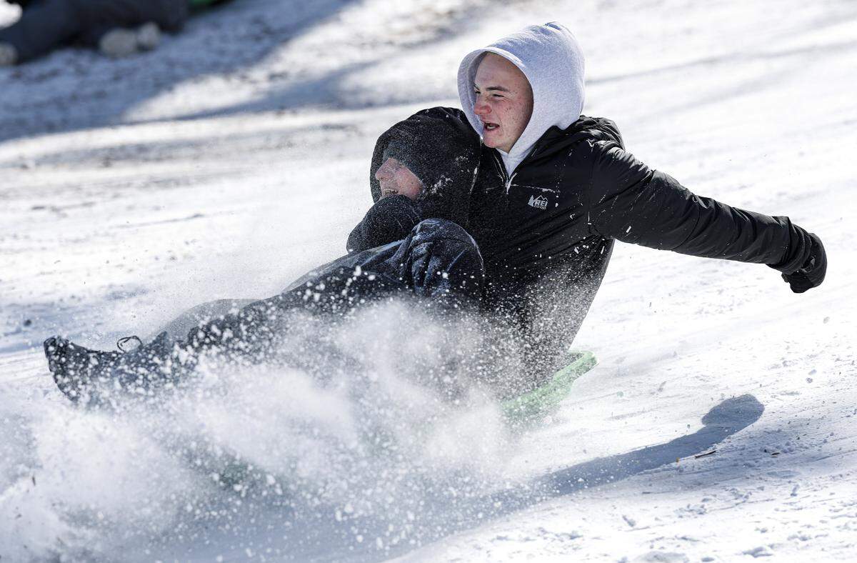 Grey Morris, right, and his brother Cooper sled down one of the hills at Dix Park in Raleigh, N.C., Sunday, Feb. 1, 2026.