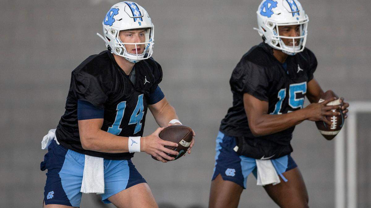 North Carolina graduate transfer quarterback Max Johnson (14) and sophomore quarterback Conner Harrell (15) work out during the Tar Heels’ opening day of spring football practice on Tuesday, March 19, 2024 in Chapel Hill, N.C.