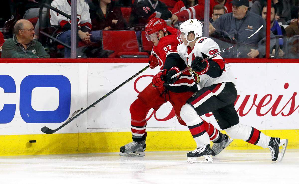The Canes’ Warren Foegele (37) battles Ottawa’s Matt Duchene (95) along the boards during 2018 NHL game at PNC Arena..