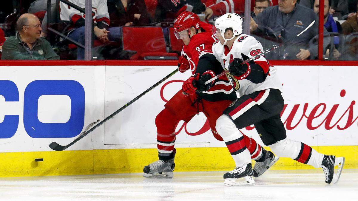 The Canes’ Warren Foegele (37) battles Ottawa’s Matt Duchene (95) along the boards during 2018 NHL game at PNC Arena..