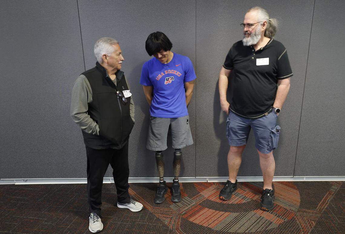 Kayden Beasley talks with his father Anthony, right, and grandfather Judson Parrish after participating in a press conference at the Lenovo Center on Feb. 24, 2026. Beasley is a member of the U.S. National Sled Hockey Team who are competing in the 2026 Paralympic Winter Games in Italy.