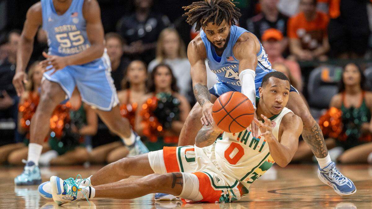 North Carolina’s R.J. Davis (4) tries for a steal from Miami’s Matthew Cleveland (0) in the first half on Saturday, February 10, 2024 at the Watsco Center in Coral Gables, Florida.