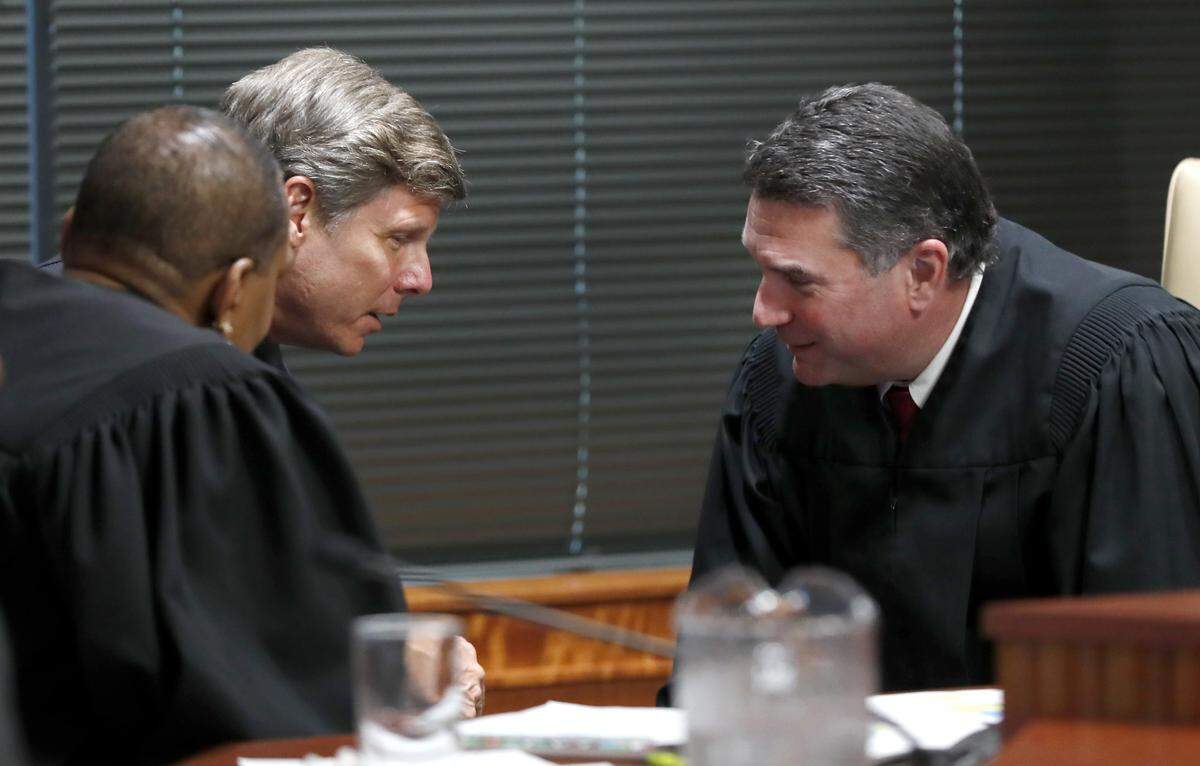 Judges Alma Hinton, left, Paul Ridgeway and Joseph Crosswhite confer during the first day of the gerrymandering trial challenging the North Carolina legislature district lines Monday, July 15, 2019. The trial is being held at Campbell University’s Law School in Raleigh, N.C.