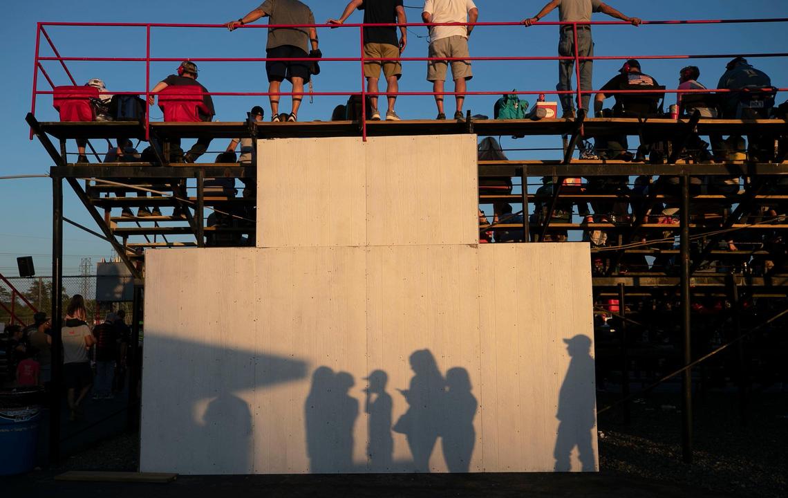 The shadows of race fans waiting in line to purchase concessions is cast up a blank wall at the Ace Speedway on Saturday, May 23, 2020 in the rural Alamance County community of Altamahaw, near Elon, N.C.