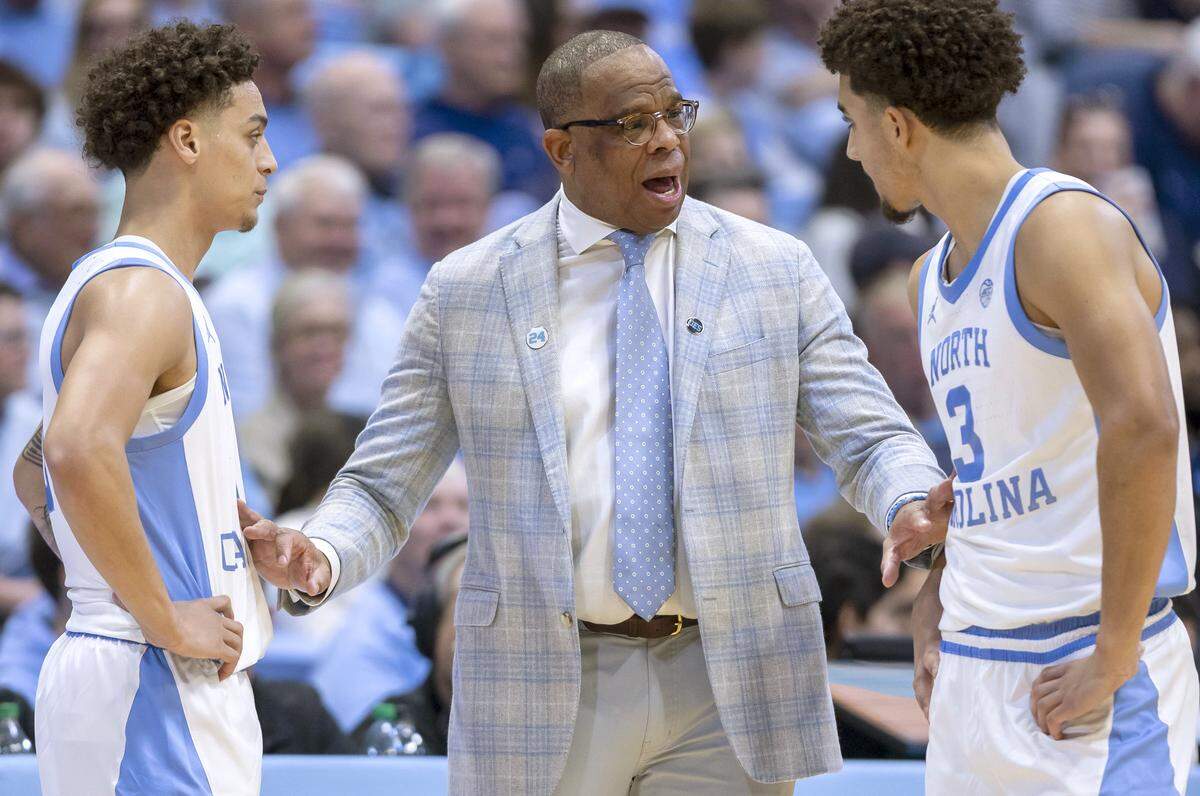 North Carolina coach Hubert Davis talks with guards Kyan Evans (0) and Derek Dixon (3) in the second half against Georgetown on Sunday, December 7, 2025 at the Smith Center in Chapel Hill, N.C.