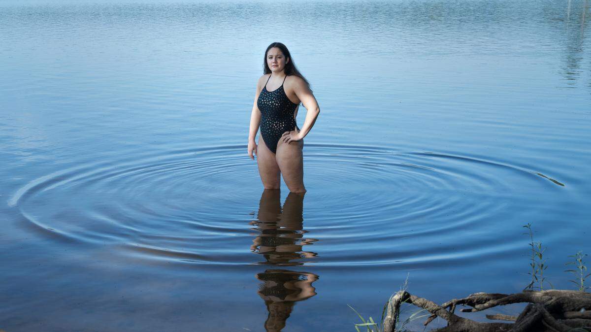 Lorelei Schmidt, 16, stands for a portrait on Tuesday, July 29, 2025 at the Beaver Dam area of Falls Lake near Durham, N.C., where she practices open water swimming.