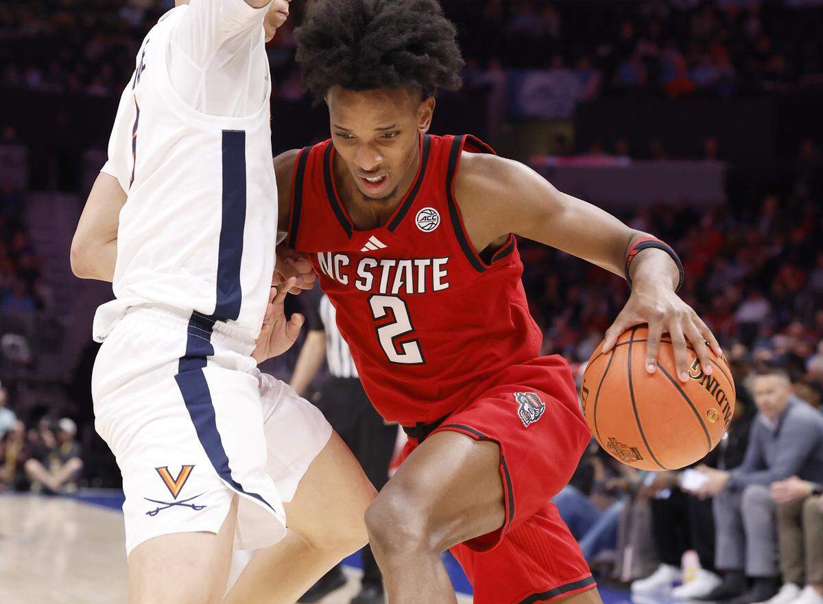 N.C. State's Paul McNeil Jr. (2) drives past Virginia's Jacari White (6) during the second half of Virginia’s 81-74 victory over N.C. State in the quarterfinals of the 2026 ACC Men’s Basketball Tournament at the Spectrum Center in Charlotte, N.C., Thursday, March 12, 2026.