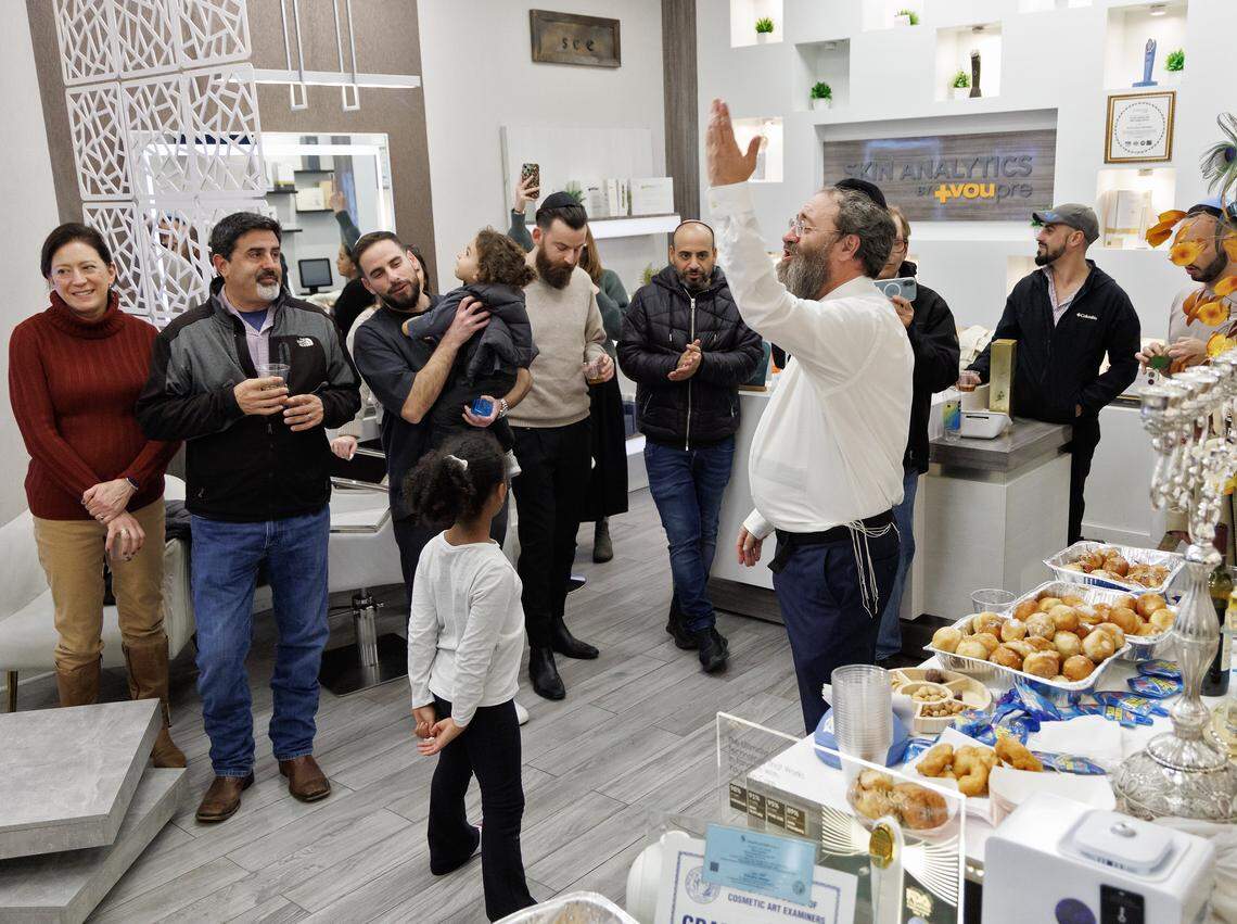 Rabbi Zalman Bluming of Chabad of Durham-Chapel Hill leads a group in song during a gathering at Skin Analytics at The Streets at Southpoint on Thursday, Dec. 18, 2025, in Durham, N.C. 
