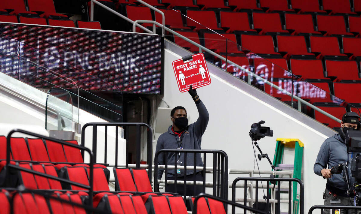 A usher reminds those fans in attendance to stay six feet apart during the second half of Virginia’s 64-57 victory over N.C. State at PNC Arena in Raleigh, N.C., Wednesday, February 3, 2021.