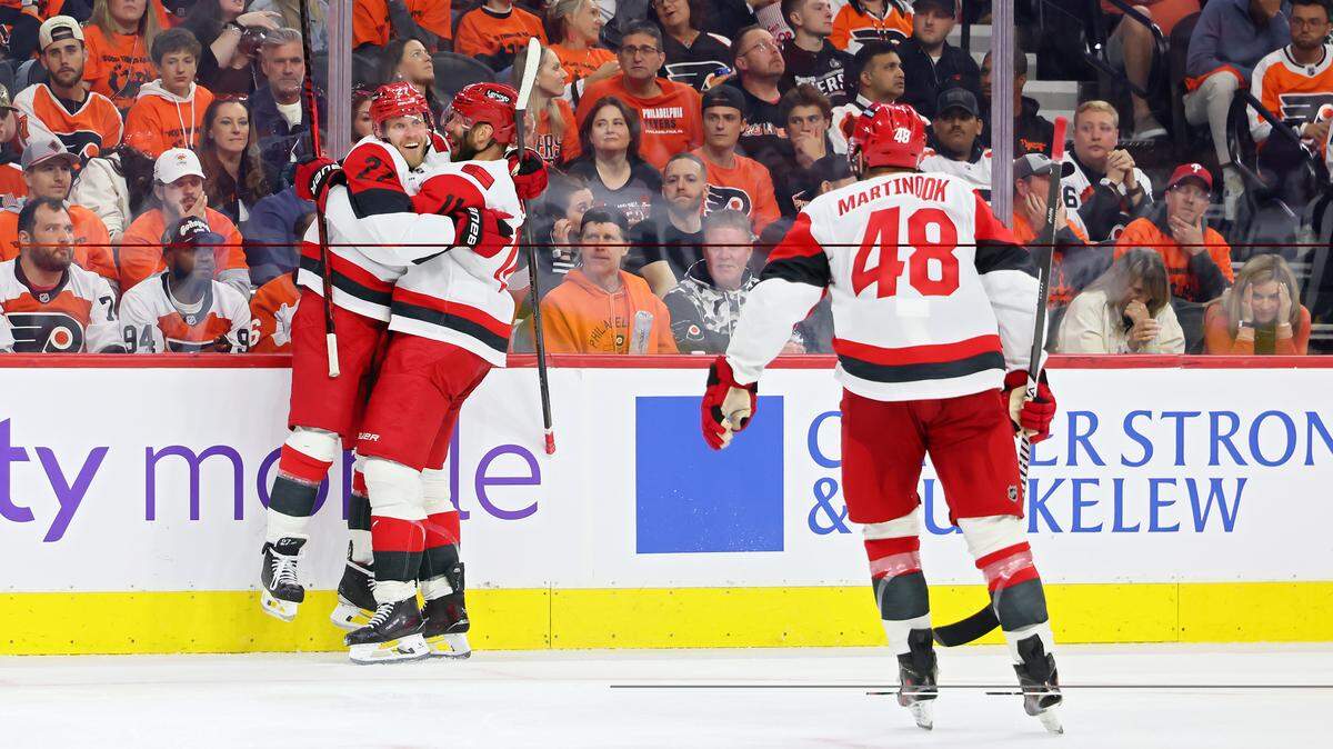 Nikolaj Ehlers (left) and Jordan Staal (center) of the Carolina Hurricanes celebrate a third-period goal against the Philadelphia Flyers as teammate Jordan Martinook skates to join the celebration in Game 3 of their second-round Stanley Cup Playoff series at Xfinity Mobile Arena on May 7, 2026 in Philadelphia, Pennsylvania.