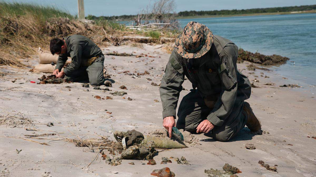 U.S. Marine Corps Sgt. Joseph Hutcher, an explosive ordnance disposal technician with Marine Corps Installations East-Marine Corps Base Camp Lejeune, digs around a piece of unexploded ordnance during a controlled demolition on Browns Island, MCB Camp Lejeune, North Carolina, May 14, 2026. Browns Island remains strictly off-limits due to ongoing live-fire training exercises and the presence of dangerous unexploded ordnance. All personnel accessing the island must be accompanied by an explosive ordnance disposal technician due to extreme dangers associated with the high-hazard impact area. For safety reasons, anchoring, disembarking, or engaging in bottom-disturbing activities are strictly prohibited on Browns Island and the surrounding waters. 