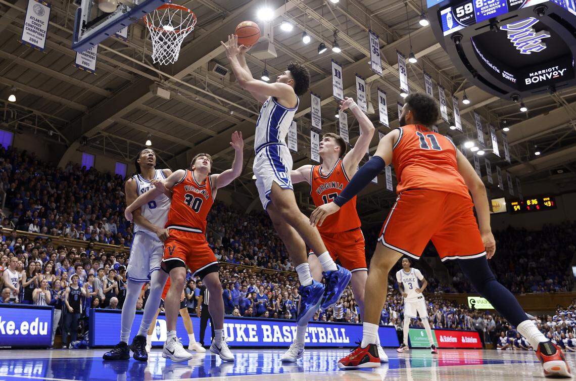 Duke’s Cameron Boozer (12) splits Virginia defenders Johann Grünloh (17) and Devin Tillis (11) to score during Duke’s 77-51 victory over Virginia at Cameron Indoor Stadium in Durham, North Carolina, Feb. 28, 2026.