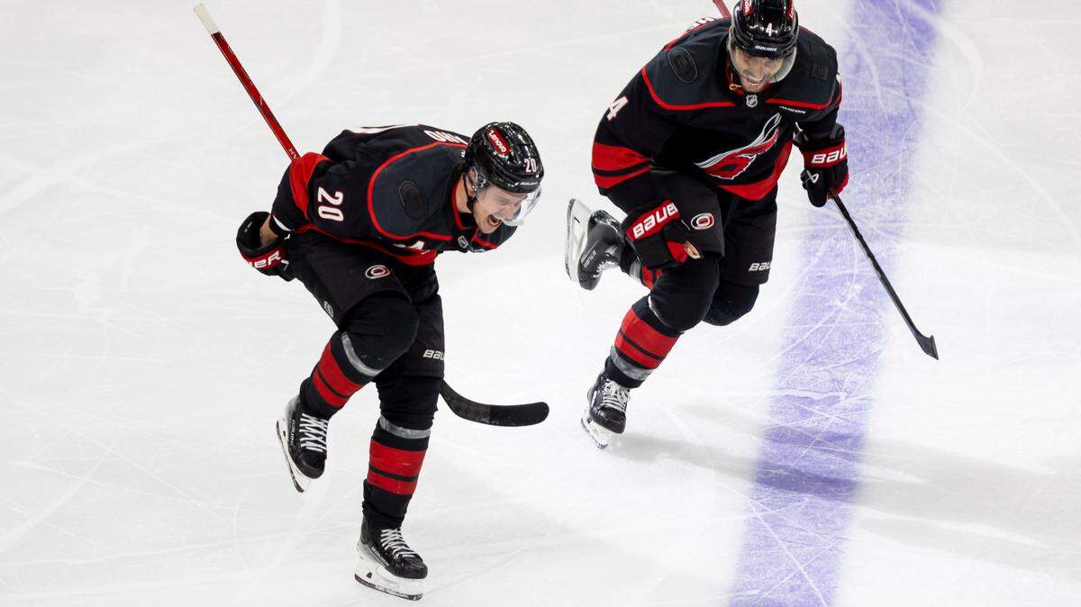 Carolina Hurricanes center Sebastian Aho (20) celebrates with teammate Shaye Gostisbehere (04) after scoring the game winning goal in double overtime to secure a 5-4 victory and clinch the first round Stanley Cup series over the New Jersey Devils on Tuesday, April 29, 2025 at Lenovo Center in Raleigh, N.C.