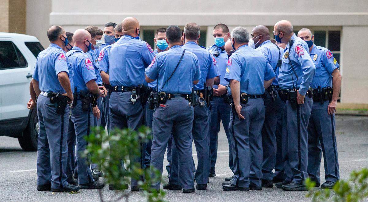 In this June 2020 file photo, Raleigh police officers huddle near a protest at the Confederate monument on the State Capitol lawn on Friday, June 19, 2020.