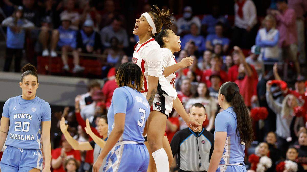 N.C. State’s Aziaha James (10) and Madison Hayes (21) celebrate late in the overtime period during N.C. State’s 77-66 overtime victory over North Carolina at Reynolds Coliseum in Raleigh, N.C., Thursday, Feb. 16, 2023.