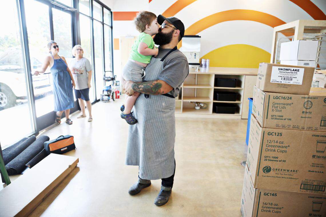 Union Special Bread owner and baker Andrew Ullom, right, kisses his son, Gus, on Wednesday, Aug. 7, 2019, as he readies the bakery for its grand opening.