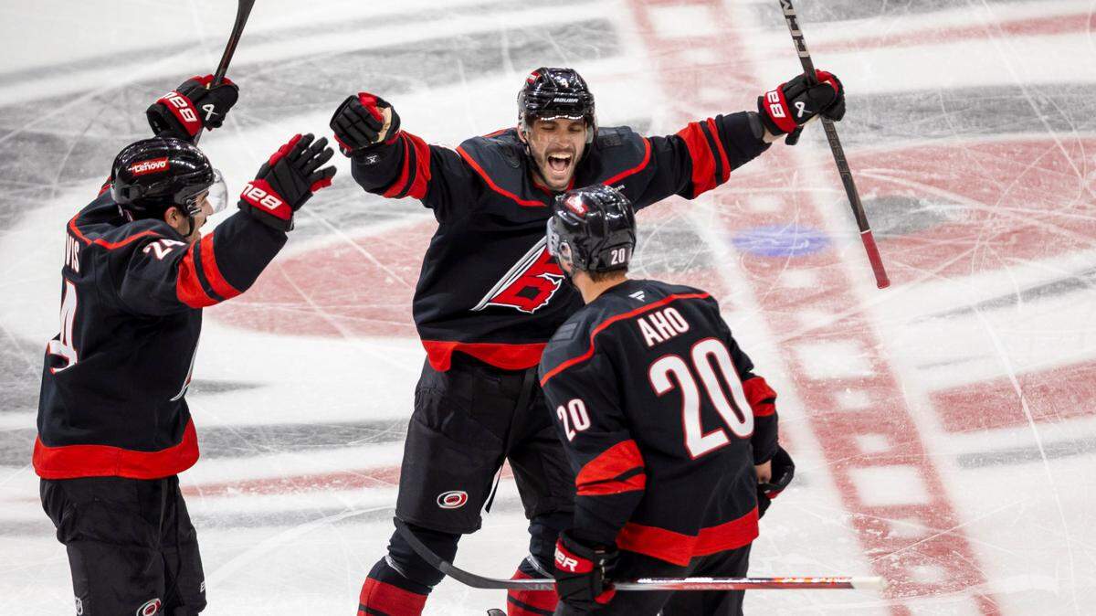 Carolina Hurricanes center Sebastian Aho (20) celebrates with teammates Shaye Gostisbehere (04) and Seth Jarvis (24) after scoring the game winning goal in double overtime to secure a 5-4 victory and clinch the first round Stanley Cup series over the New Jersey Devils on Tuesday, April 29, 2025 at Lenovo Center in Raleigh, N.C.