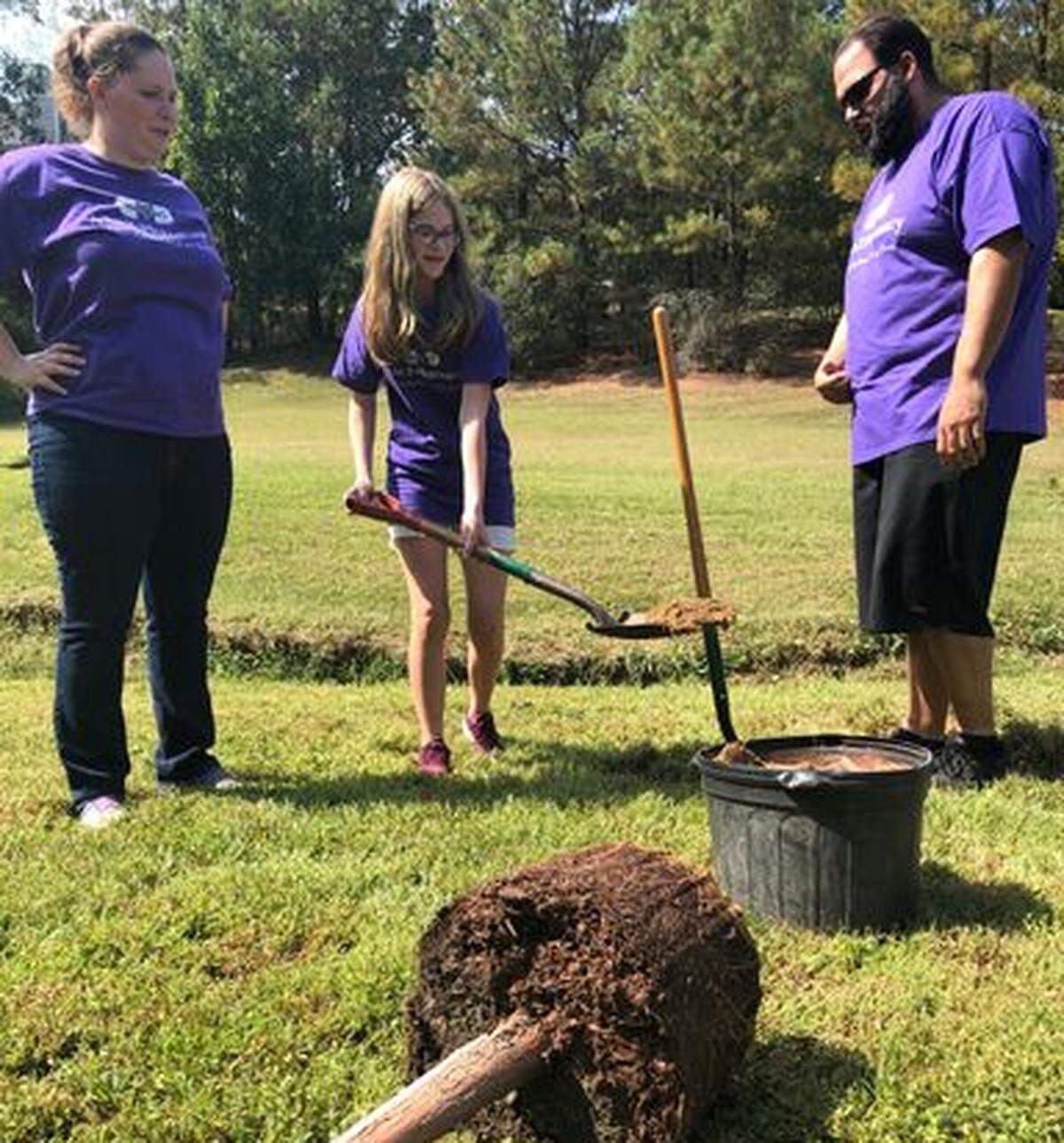 Kristen Moore with her daughter Abby and husband Nate, planting a tree for the community in which she opened her A to Z Pharmacy, photographed on Sept. 28.